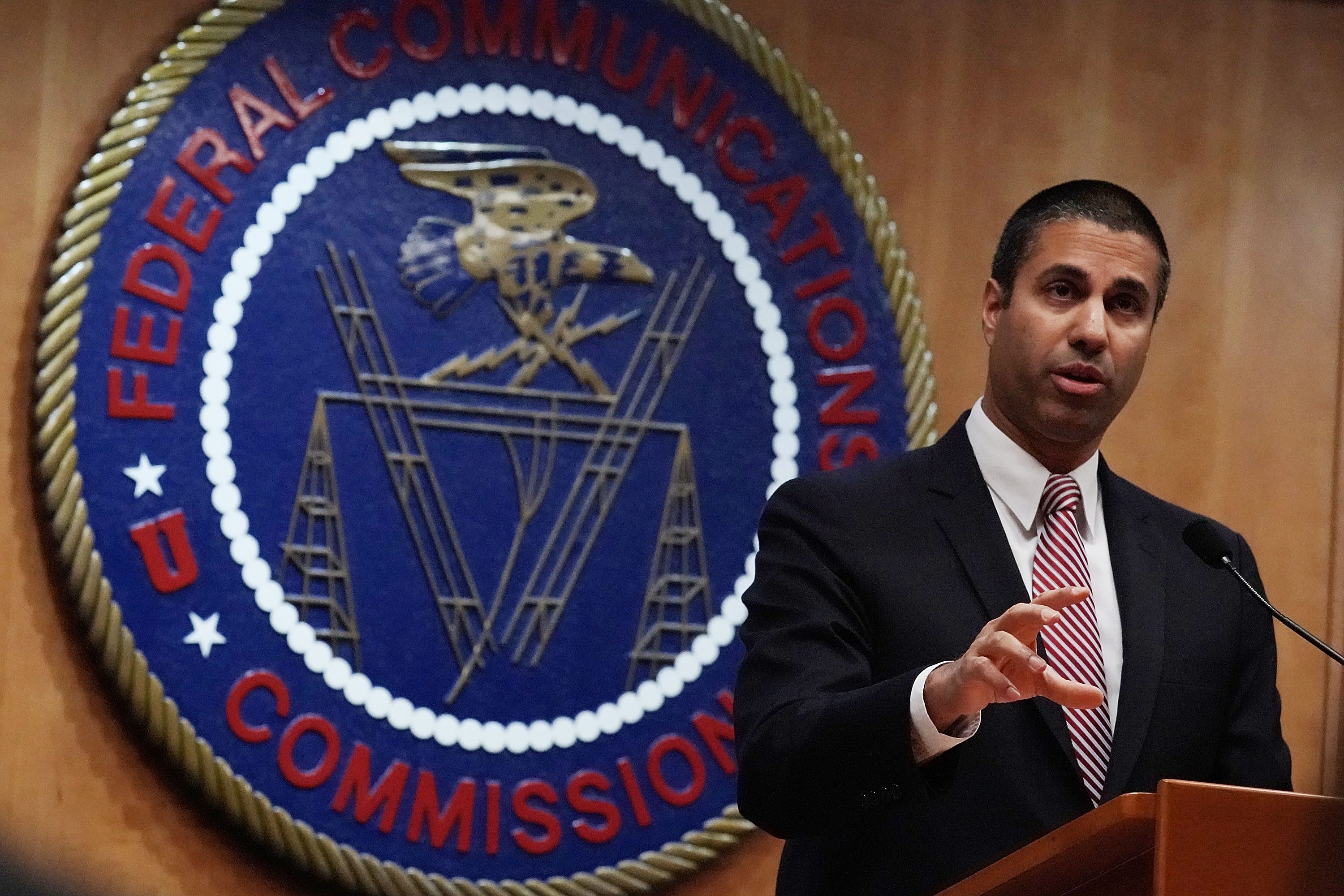 FCC Chairman Ajit Pai stands at a podium in front of the Federal Communications Commission plaque