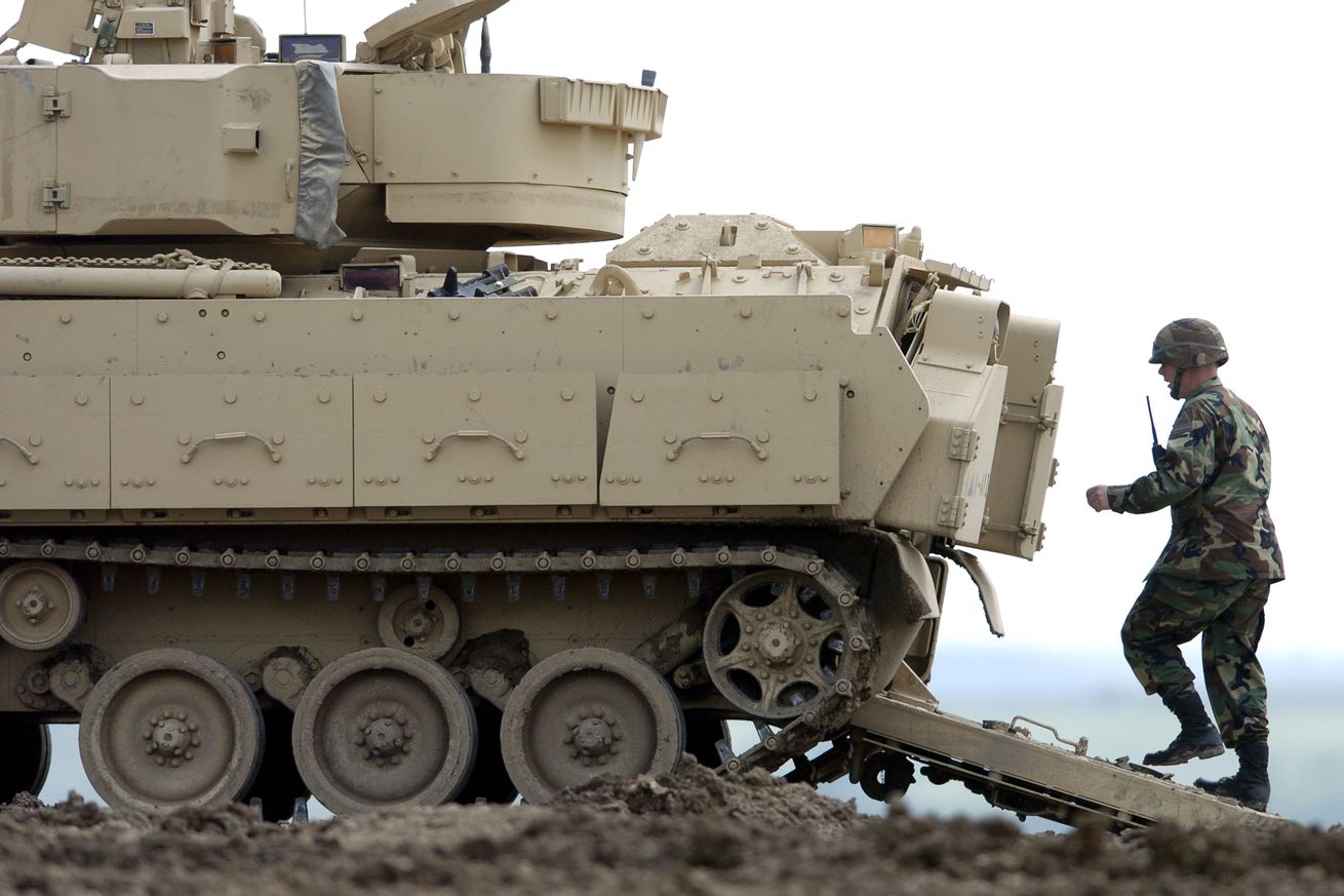 A soldier walks into the back of a Bradley Fighting Vehicle during training in Fort Riley, Kansas. 