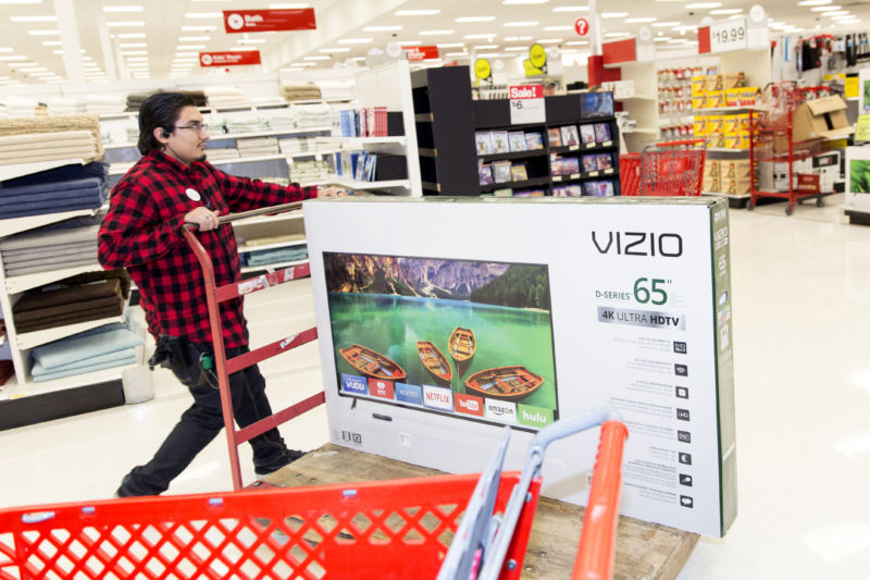 Man pushes heavily laden cart in big-box store.