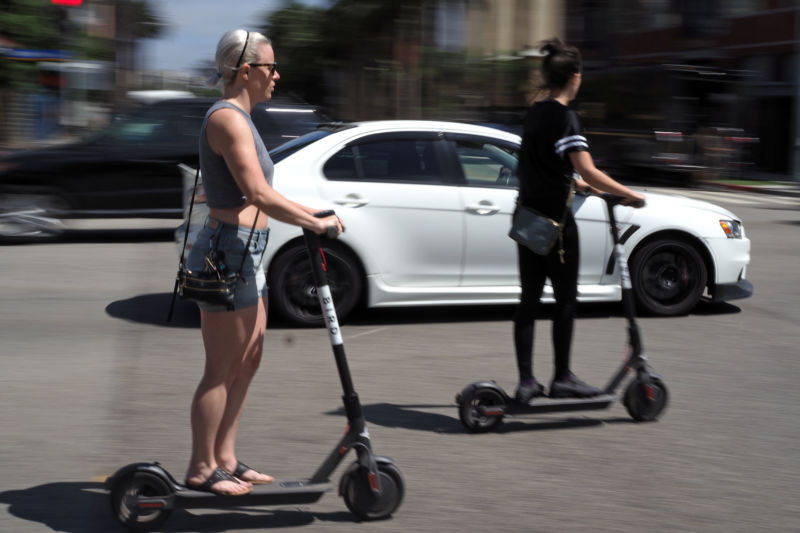 People ride shared electric scooters in Santa Monica, California, on July 13, 2018. 