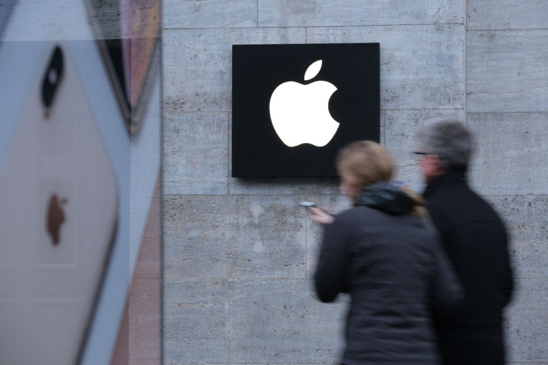 A woman holding a smartphone walks past the Apple Store on January 04, 2019 in Berlin.
