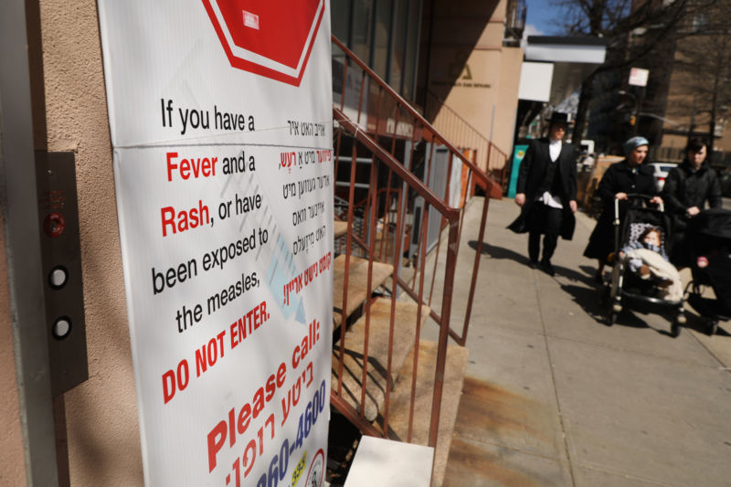 A sign warns people of measles in the ultra-Orthodox Jewish community in Williamsburg on April 10, 2019 in New York City. Mayor Bill de Blasio recently announced a state of emergency and mandated residents at the center of the outbreak to get vaccinated for the viral disease.