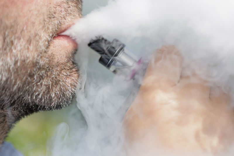 A man smokes an e-cigarette.