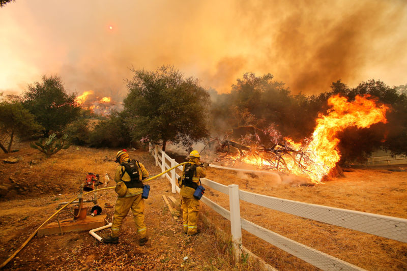 Firefighters from Stockton, Calif., put out flames off of Hidden Valley Rd. while fighting a wildfire, Friday, May 3, 2013 in Hidden Valley, Calif. (AP Photo/Los Angeles Times, Mel Melcon)