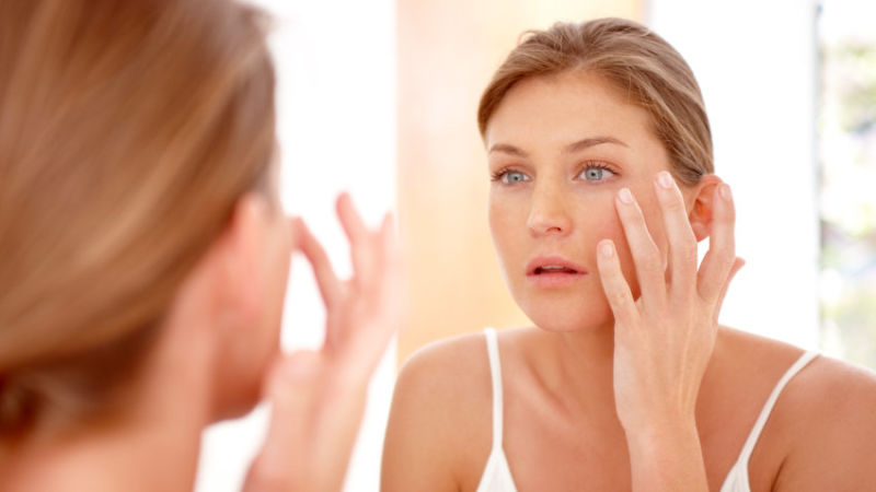 A woman applying cream in a mirror (not the woman at the center of this health story, though).