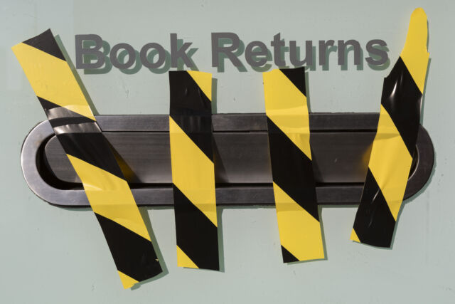 Hazard tape blocks the book returns slot at a London library.