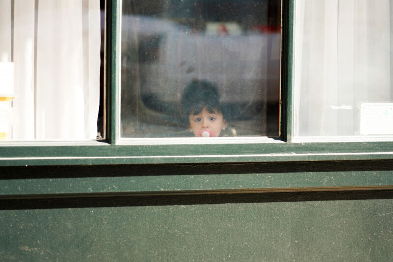 NEW YORK, NEW YORK - MARCH 24: A child with a pacifier looks out a window as the coronavirus continues to spread across the United States on March 24, 2020 in New York City. The World Health Organization declared COVID-19 a global pandemic on March 11th. (Photo by Cindy Ord/Getty Images)
