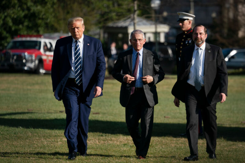 Image of three men walking across a lawn.