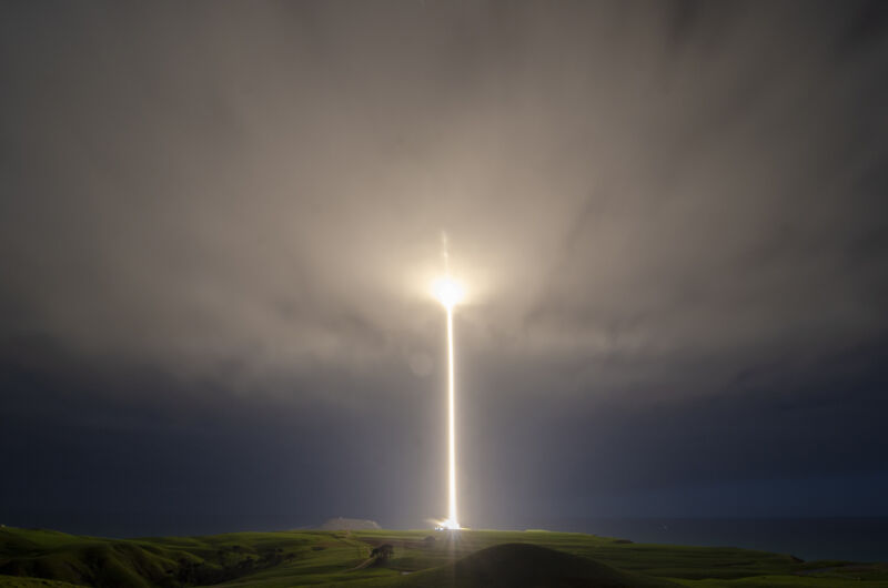 A rocket leaves a trail of light and fire as it lifts into the clouds.