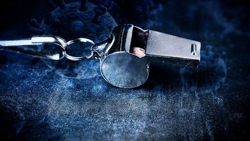 Closeup photograph of a coach's whistle on a blue background.