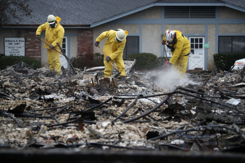 Search and rescue crews dig through the burnt remains of a business as they search for human remains on November 21, 2018 in Paradise, California. Fueled by high winds and low humidity, the Camp Fire ripped through the town of Paradise, charring over 150,000 acres.