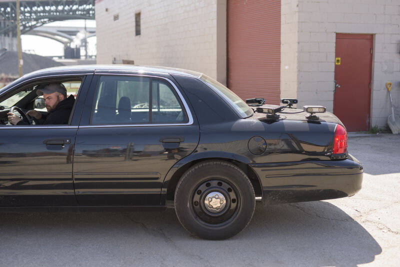 The trunk of a black sedan is dotted with electronic devices.