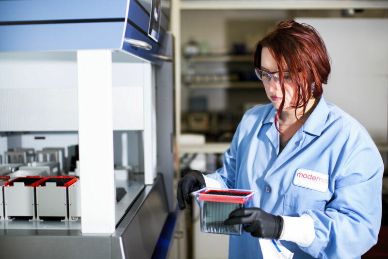 Image of a woman in a lab coat holding scientific instruments.