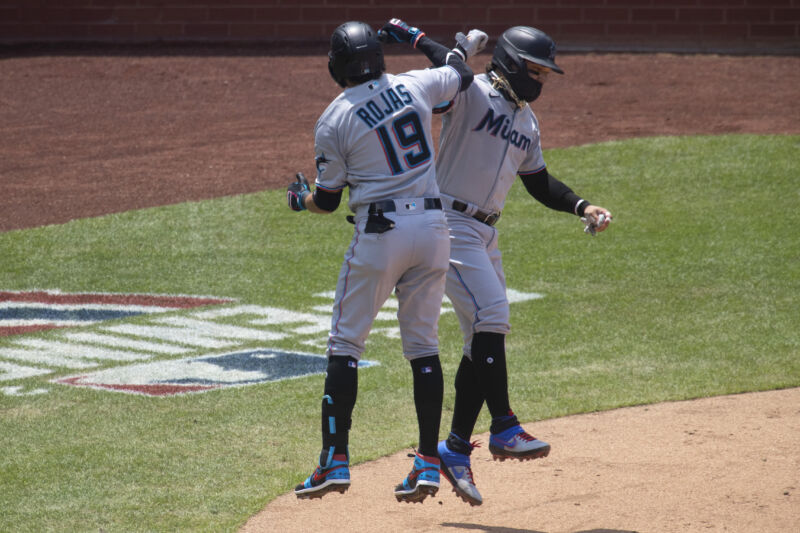 Swapping elbow bumps for high-fives and adding some mask use among players was not enough to prevent an outbreak of COVID-19 among the Miami Marlins. (Miami players Miguel Rojas and Isan Diaz celebrating during a game against the Phillies, July 26, 2020 in Philadelphia.)