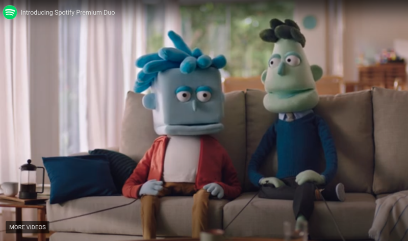 Screenshot from commercial features two puppets conversing on a sofa.