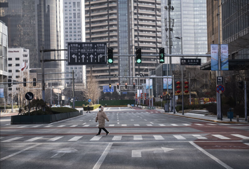 Few people and no cars dot a street amidst highrises.