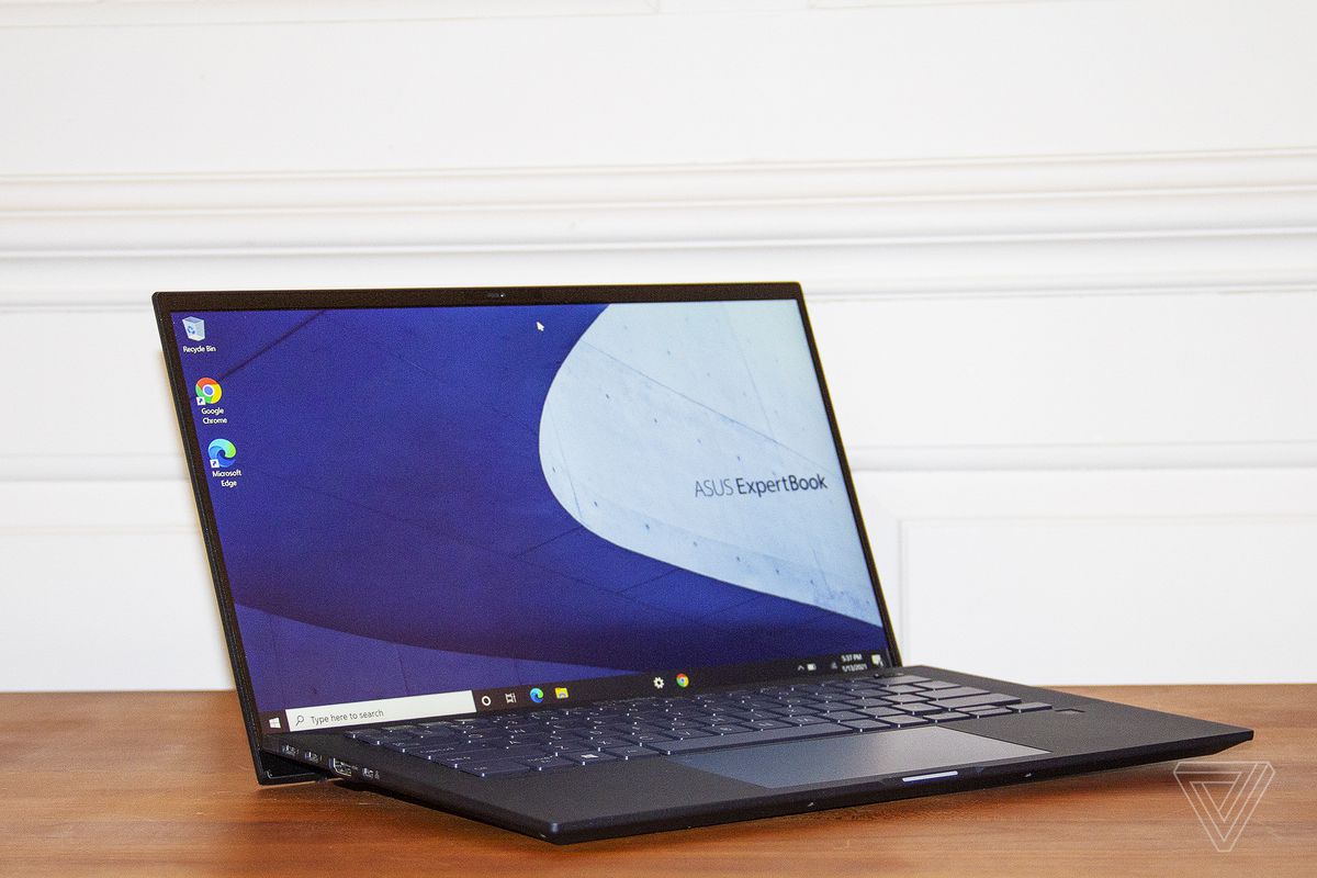 The Asus ExpertBook B9450 open, angled slightly to the right. The screen displays the Asus ExpertBook logo on a blue and white background.