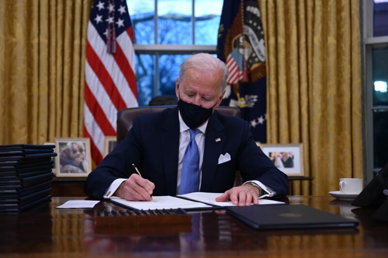 US President Joe Biden sits in the Oval Office as he signs a series of orders at the White House in Washington, DC, after being sworn in at the US Capitol on January 20, 2021.