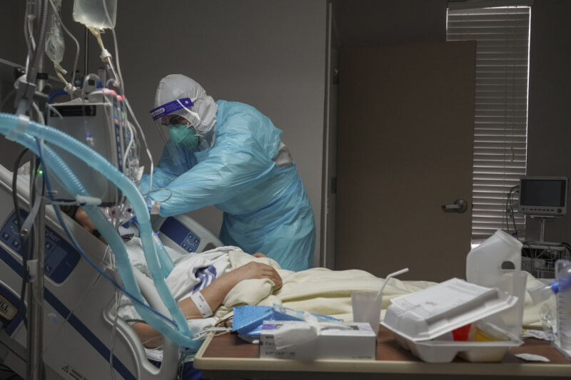 A medical staff member adjusts a ventilator on a patient in the COVID-19 intensive care unit (ICU) at the United Memorial Medical Center on December 2, 2020 in Houston, Texas. 