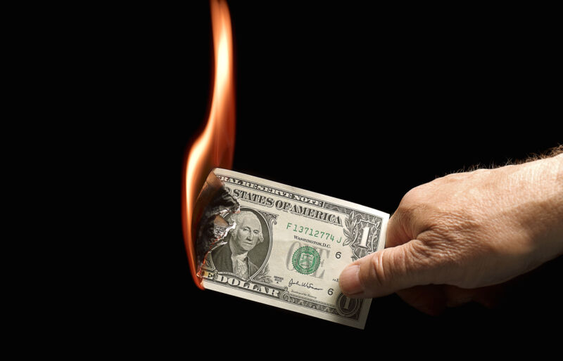 A one-dollar bill set on fire.