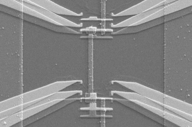 Scanning electron micrograph shows the device used to implement the gambling demon. The tapered structures on each side are electrodes from which single electrons can jump onto the strip-shaped copper island in between. Each jump is like a gas molecule passing through the demon’s shutter.&nbsp;