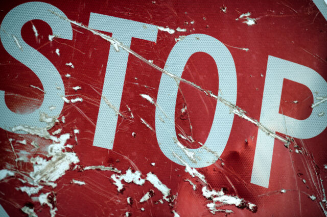 Close-up of a red stop sign after a traffic accident. The sign is heavily scratched and dented. Many vehicle accidents are attributed to drunk driving in Hawaii. Unfortunately many end up as fatalities.