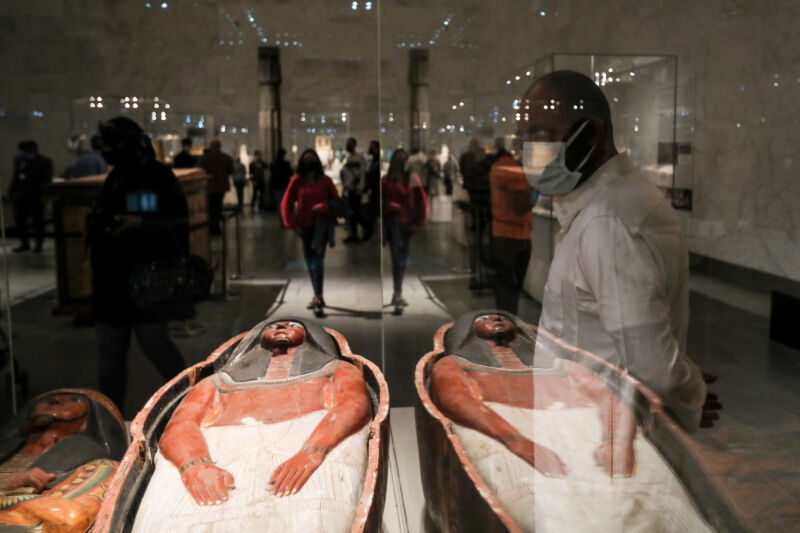 A visitor looks at displayed artifacts at the National Museum of Egyptian Civilisation (NMEC) during its official reopening a day after the Pharaohs' Golden Parade ceremony, a procession held to transport the mummified bodies of 22 ancient Egyptian kings and queens from the Egyptian Museum to their new resting place at the NMEC.