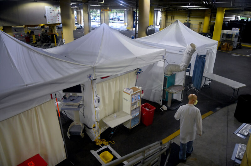 Emergency medicine specialist Dr. Davis Wein walks in a parking garage that was turned into a series of COVID-19 test tents at Tampa General Hospital in Tampa, Florida, on August 19, 2020. 