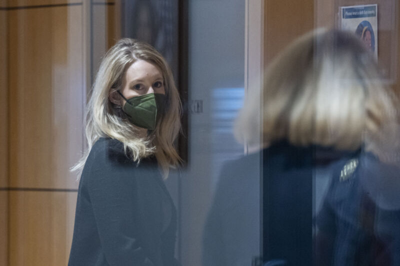 Elizabeth Holmes, founder of Theranos Inc., left, arrives at federal court in San Jose, Calif., on Tuesday, Oct. 12, 2021.