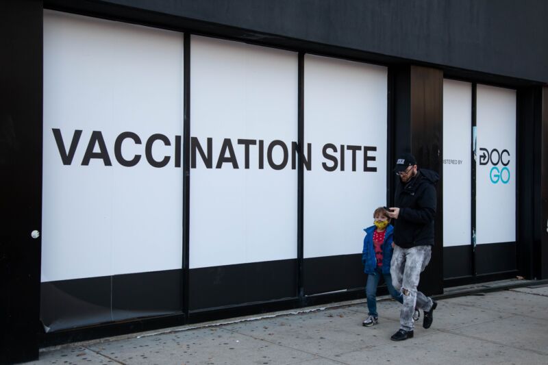Pedestrians walk in front of a COVID-19 vaccination site in Brooklyn, New York, on Nov. 19, 2021.