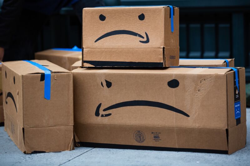 Cardboard boxes made to resemble Amazon packages, but with the logo in the shape of a frown.