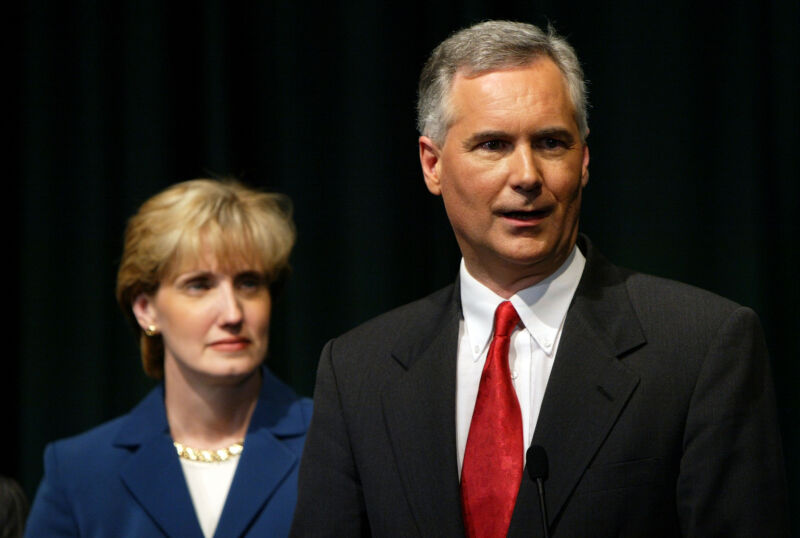 Tom McClintock speaks to reporters with his wife, Lori, after participating in a debate at California State University, Sacramento, September 24, 2003, in Sacramento, California.