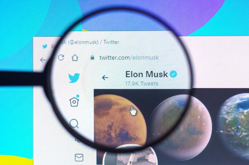 In this photo illustration, Elon Musk's official Twitter profile seen on a computer screen through a magnifying glass.
