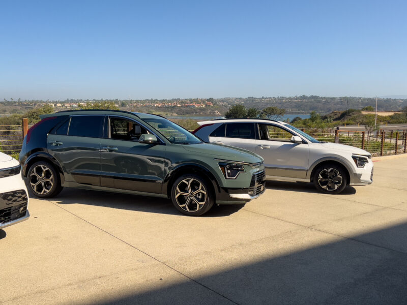 A green Kia Niro hybrid and a white Kia Niro EV