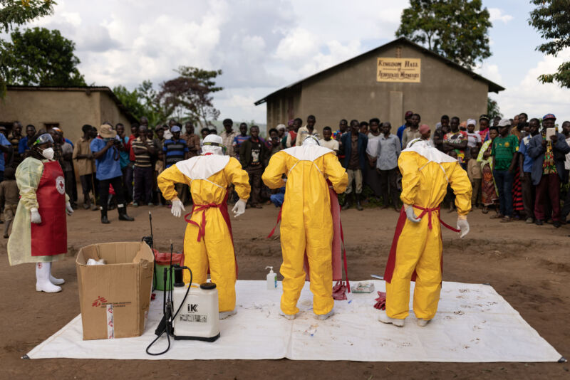 Red Cross workers don PPE prior to burying a 3-year-old boy suspected of dying from Ebola in 2022 in Mubende, Uganda. 