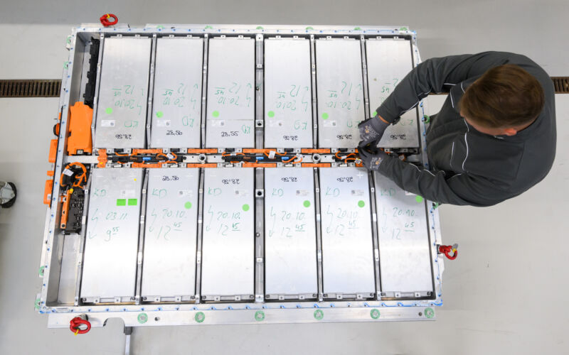 18 May 2022, Lower Saxony, Salzgitter: An employee removes battery modules from a worn-out battery of an electric car in battery recycling at the VW plant in Salzgitter. Volkswagen is building a battery cell factory at its Salzgitter site for its planned large-scale production of the Group's own battery cells. New battery systems for electric cars are already being developed at the research and development center.