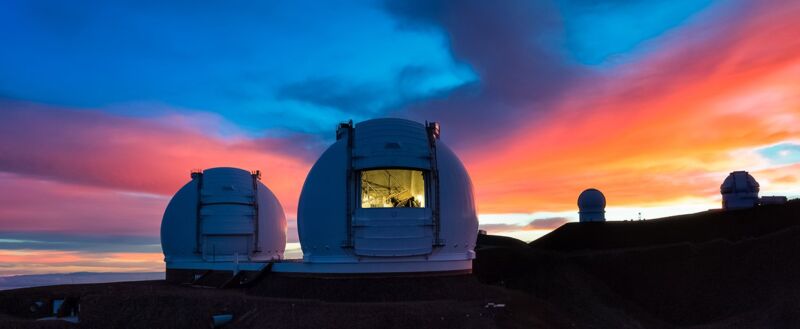 Image of two large domes against the backdrop of a pink sunset.