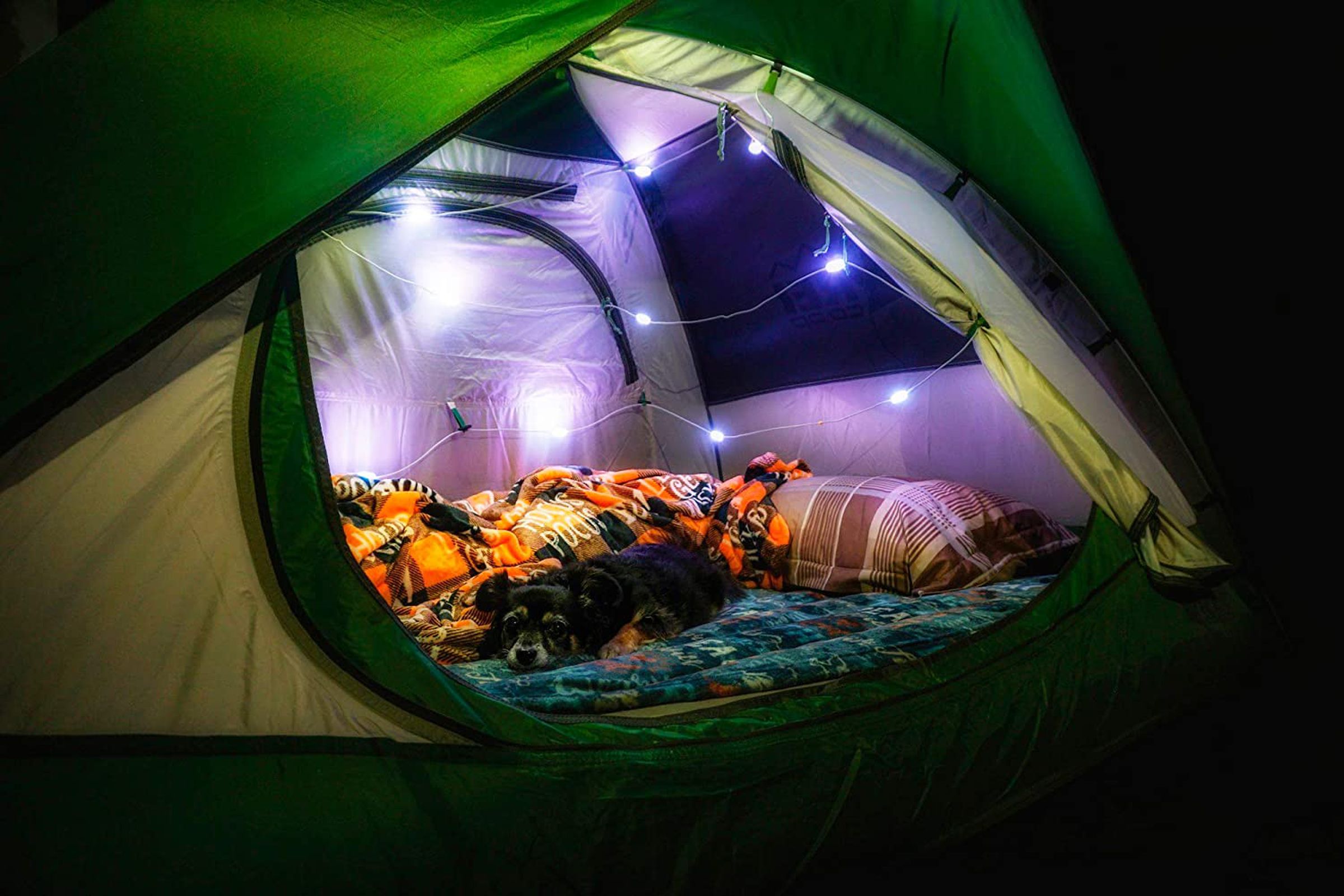 A string of multicolored lights inside of a tent.