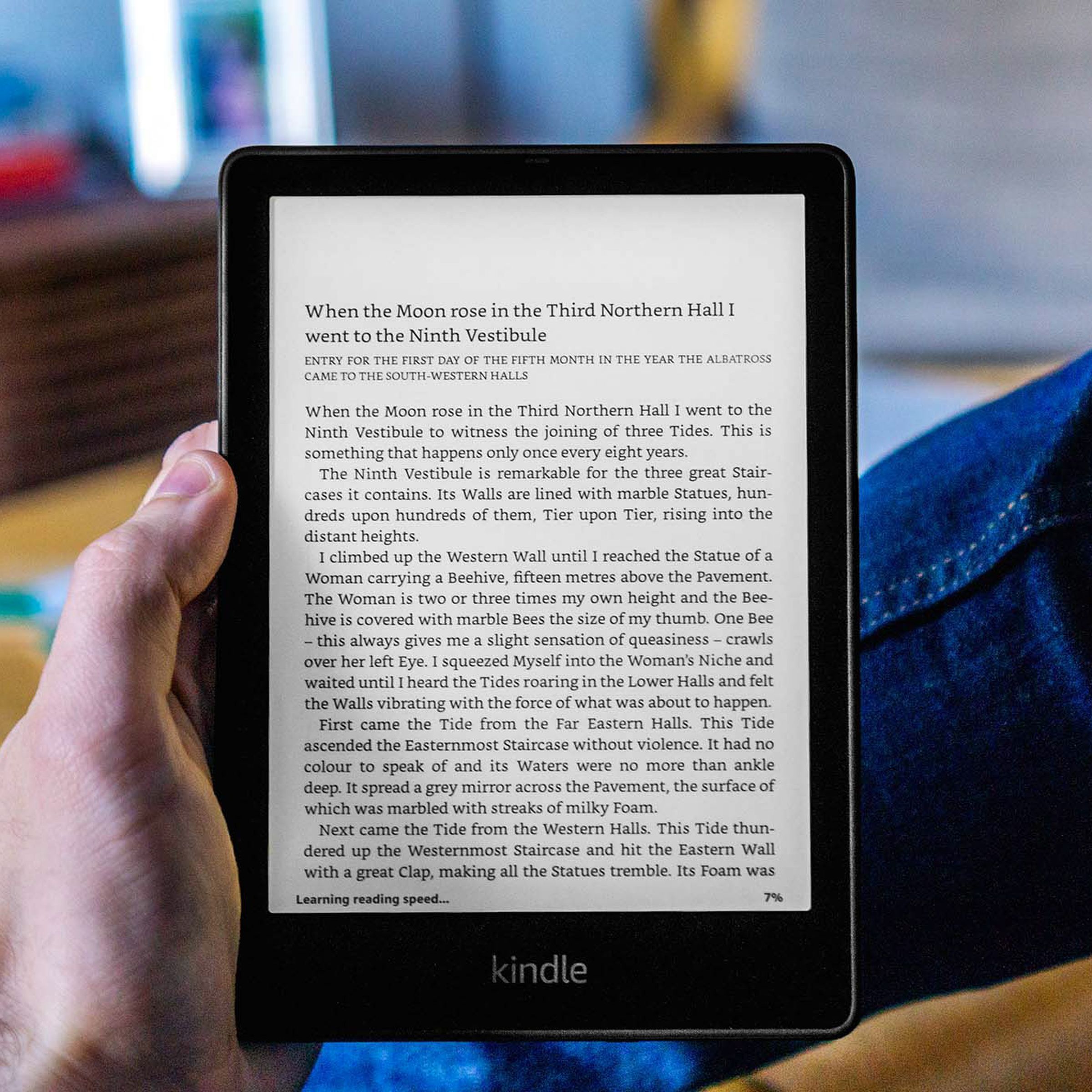 A hand holding up the Kindle Paperwhite