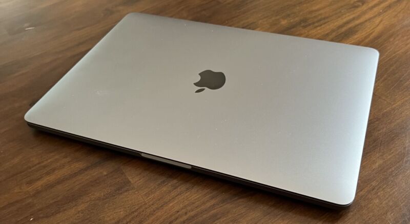 A Mac laptop on a table with the lid closed