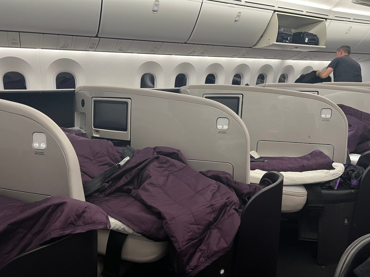 The awkwardly angled business class seats on ANZ with purple blankets.