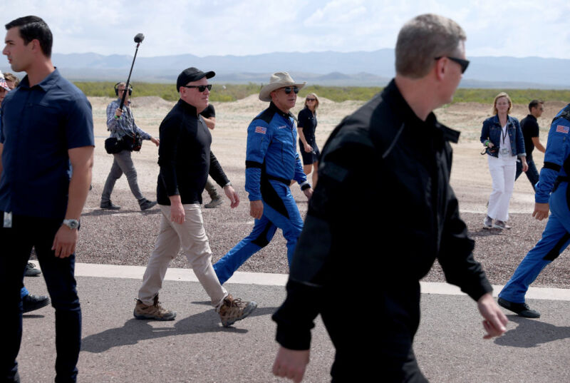 Blue Origin CEO Bob Smith (black hat) walks with Jeff Bezos after his flight on Blue Origin’s New Shepard into space in July 2021.