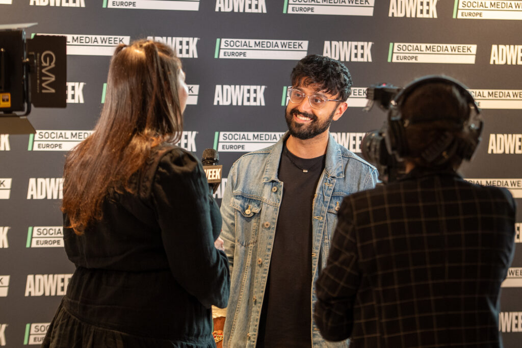 a man in a denim jacket being interviewed and videotaped