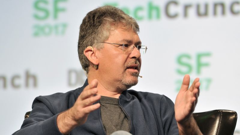 John Giannandrea gestures while speaking at a TechCrunch conference