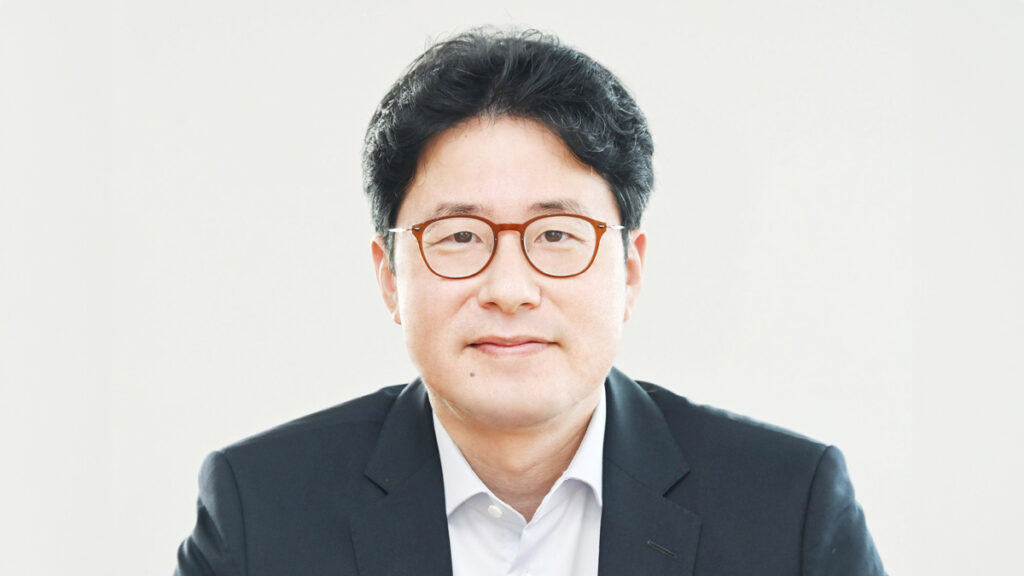 a korean man wearing brown-rimmed glasses