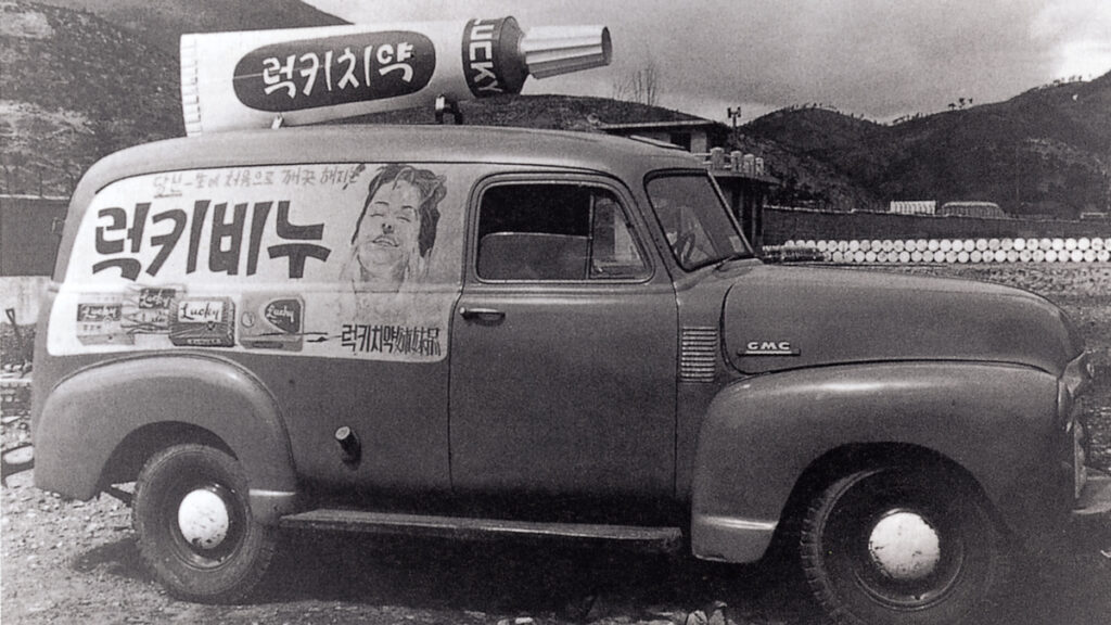 a black and white photo of a van with a sticker advertising face cream