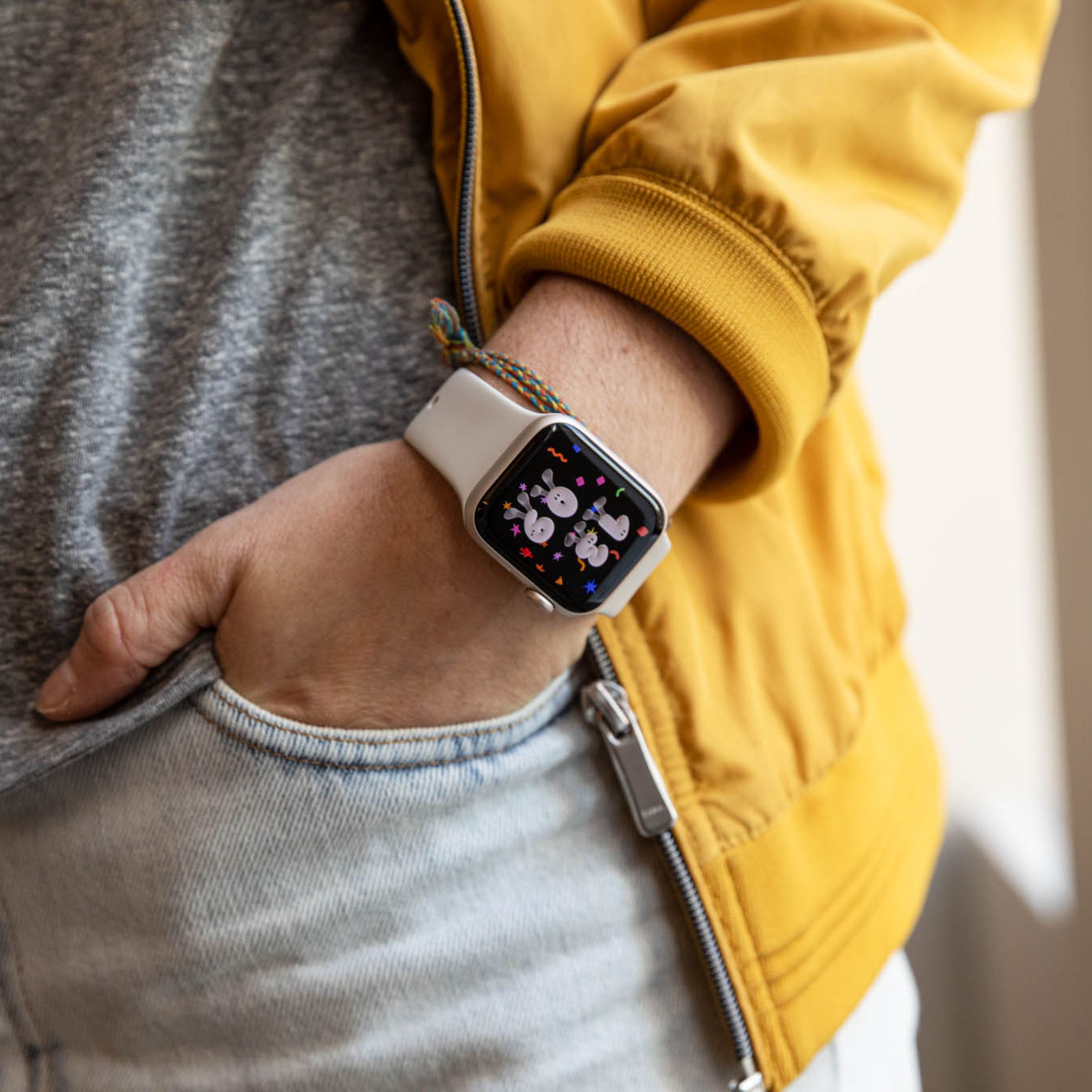 Man in yellow jacket models Apple Watch SE (2022)