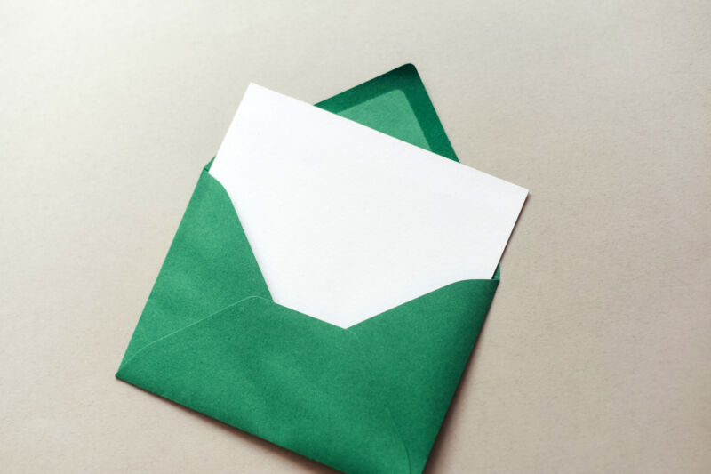 A green envelope with a white card within it.