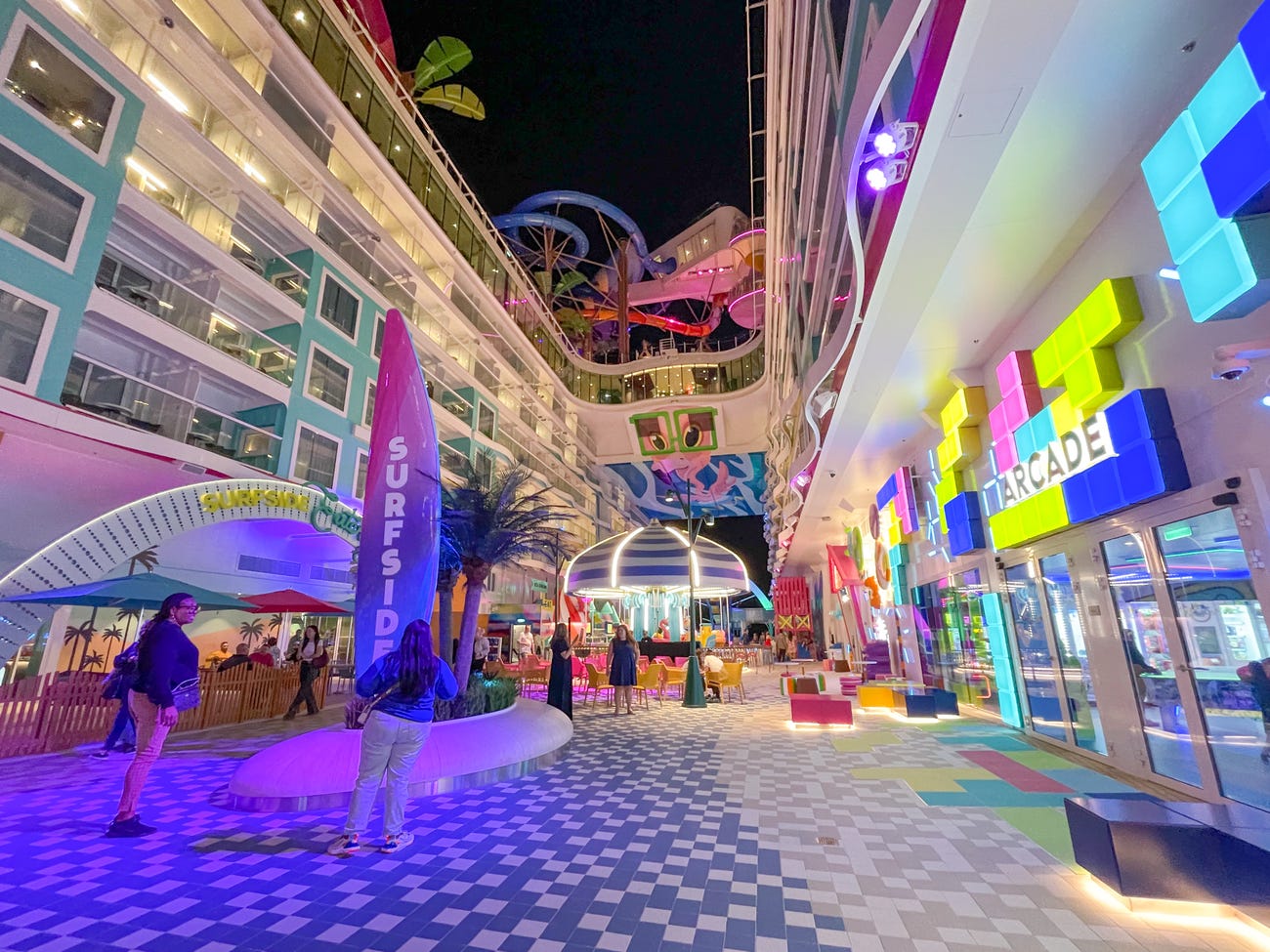 Icon of the Seas Surfside neighborhood at night with neon lights