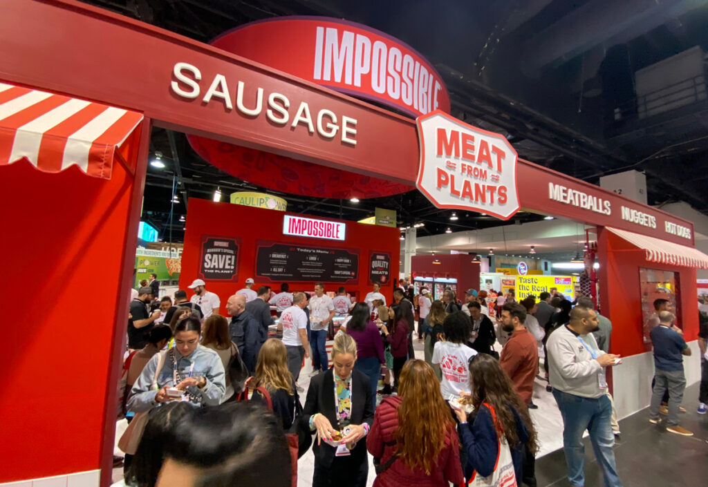 people hanging out around the impossible foods booth at expo west 2024